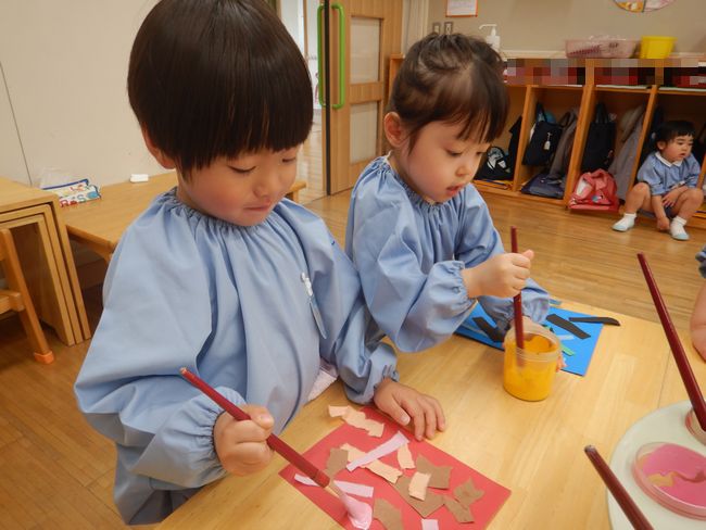 絵の具を使ってこいのぼり制作に取り組む年少児