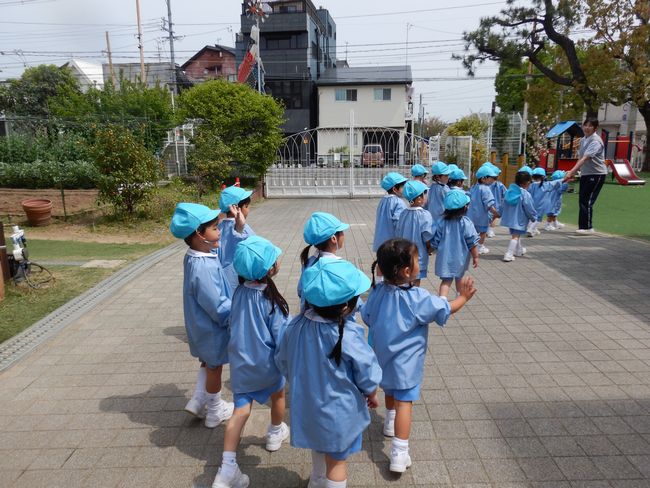 春の戸外を散歩する年少組。