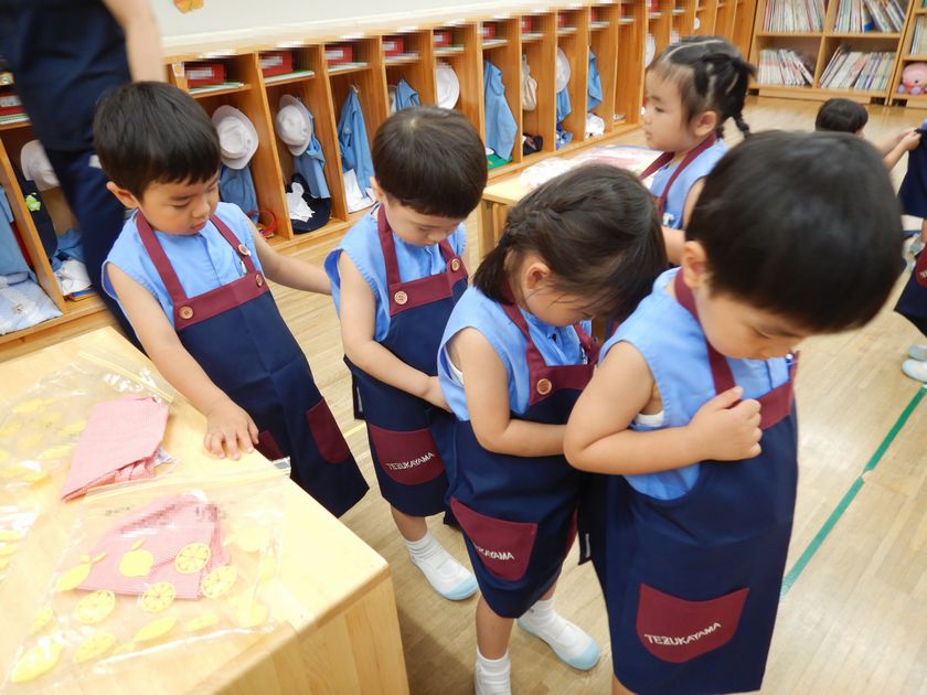 エプロンをつける子ども