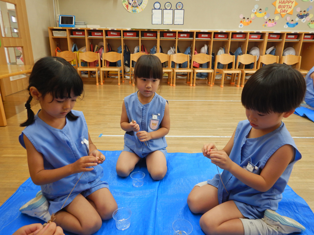 子どもが小麦を脱穀しているところ