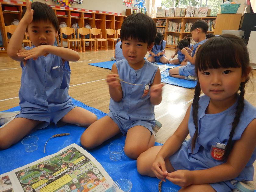 子どもが小麦の脱穀をしているところ