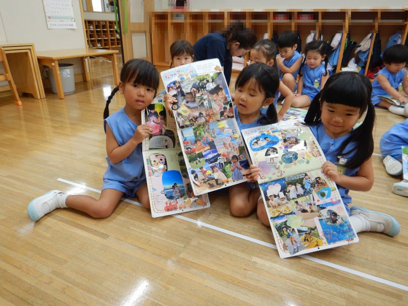 夏休みの思い出の写真を見せる園児