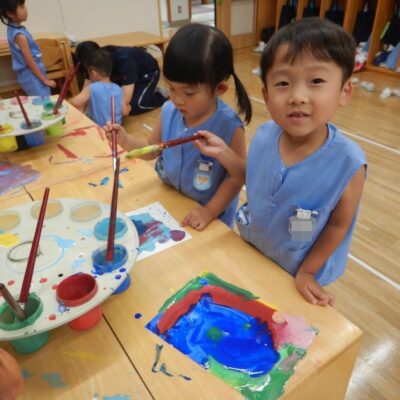 絵の具で絵を描く園児