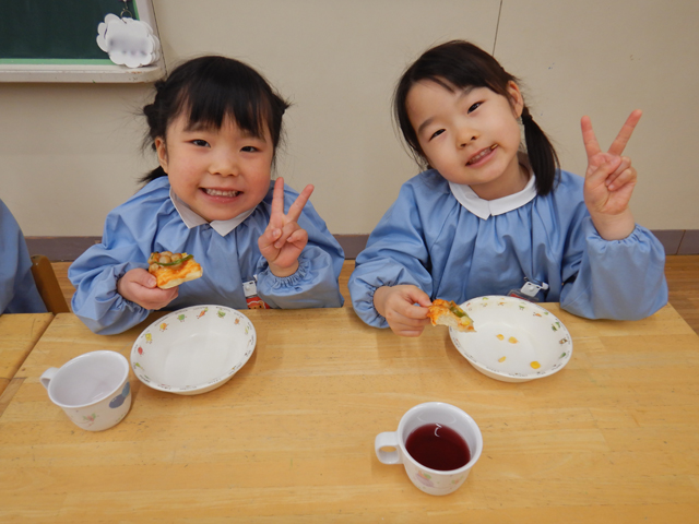 ピザをたべる子ども